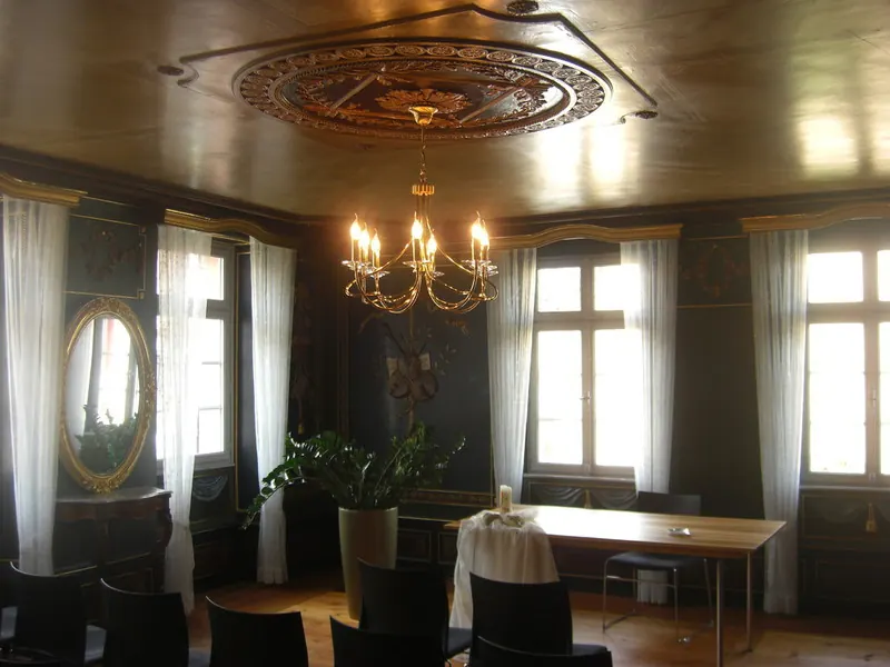 Saal mit Holzdecke, Deckenrosette und Kronleuchter