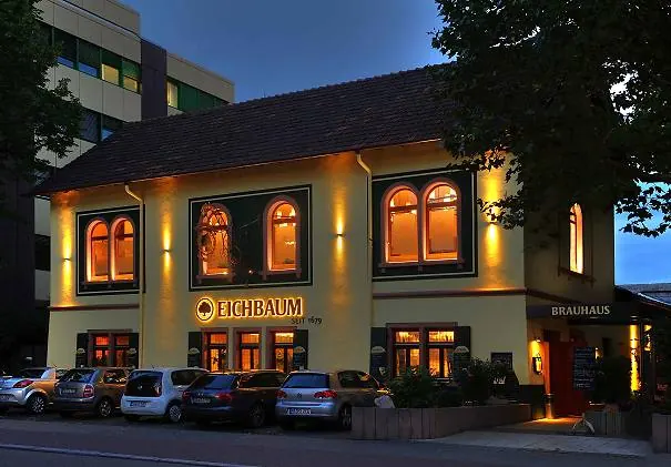 Gaststättenfassade am Abend mit warmen Wandflutern