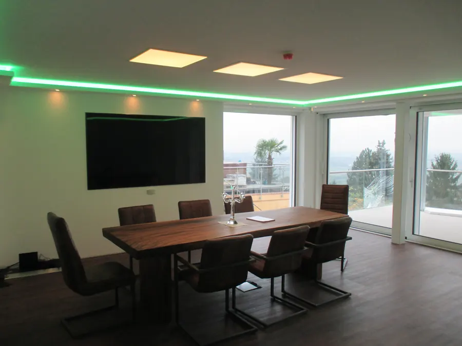 Besprechungsraum mit LED-Panels und grüner Lichtvoute